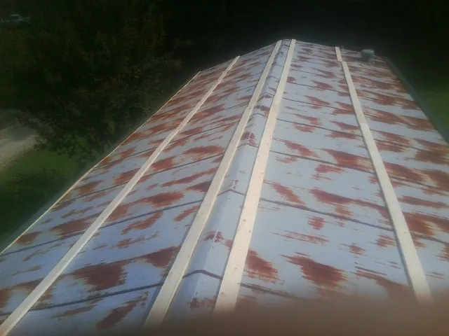 Rusted metal roof panels with new wood purlins before replacement — Storm Damage Roof Repair in McCammon by Roofing Brothers