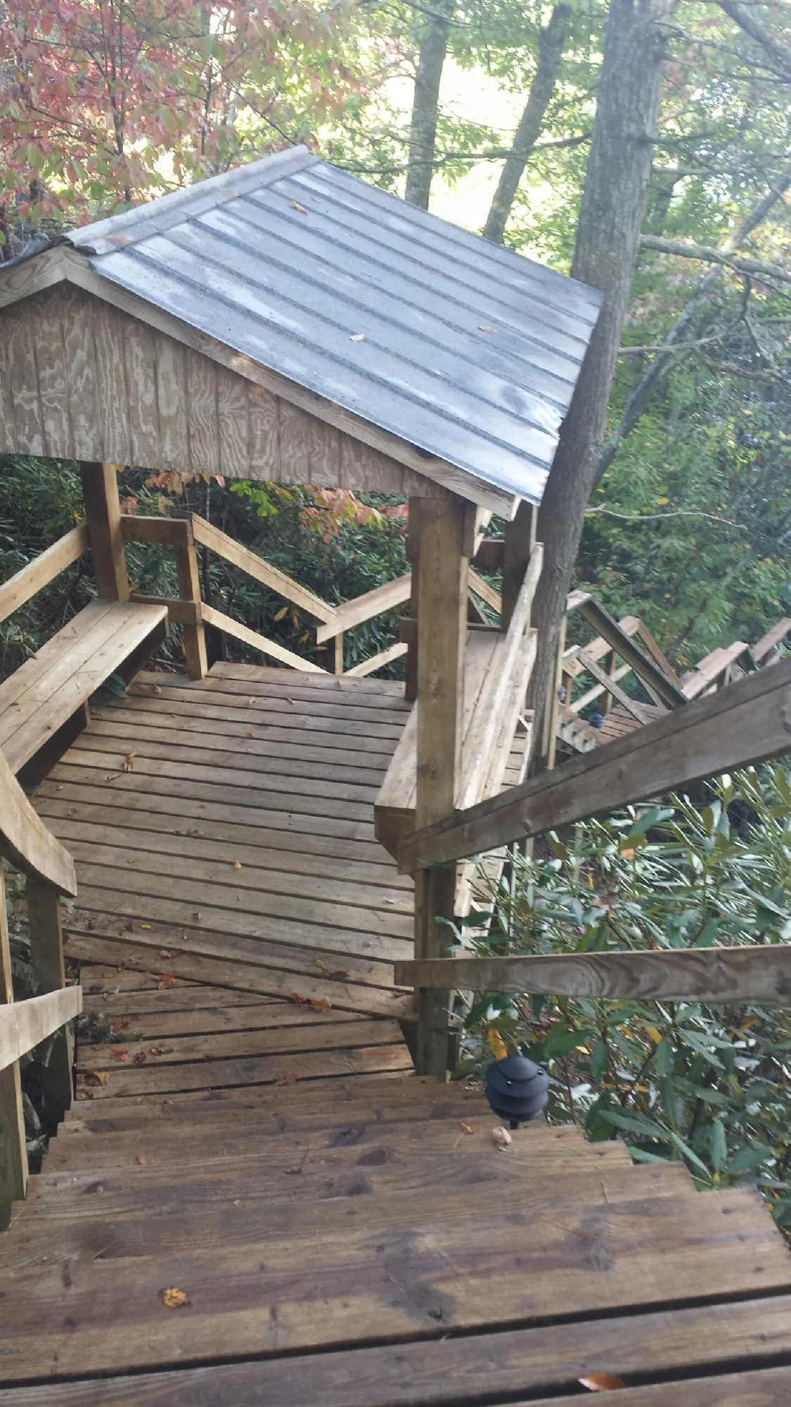 Metal roofed shelter over wooden steps on a wooded walkway — Skylight Repair & Installation work by our crew in McCammon