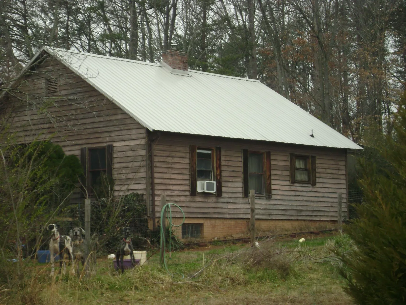 White metal roof on an old wood sided farmhouse, from a Metal Roof Installation job in McCammon
